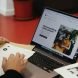 A person sitting at a table with a laptop
